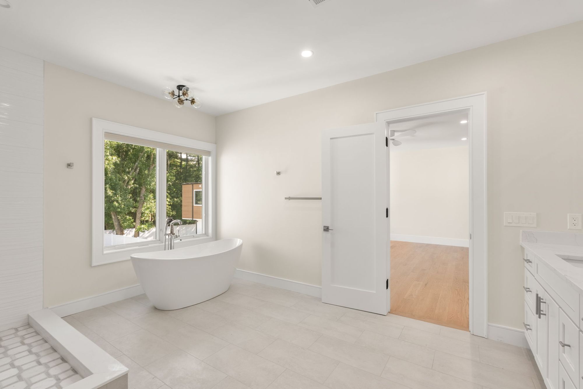 Primary bath with a freestanding soaking tub under a wide window