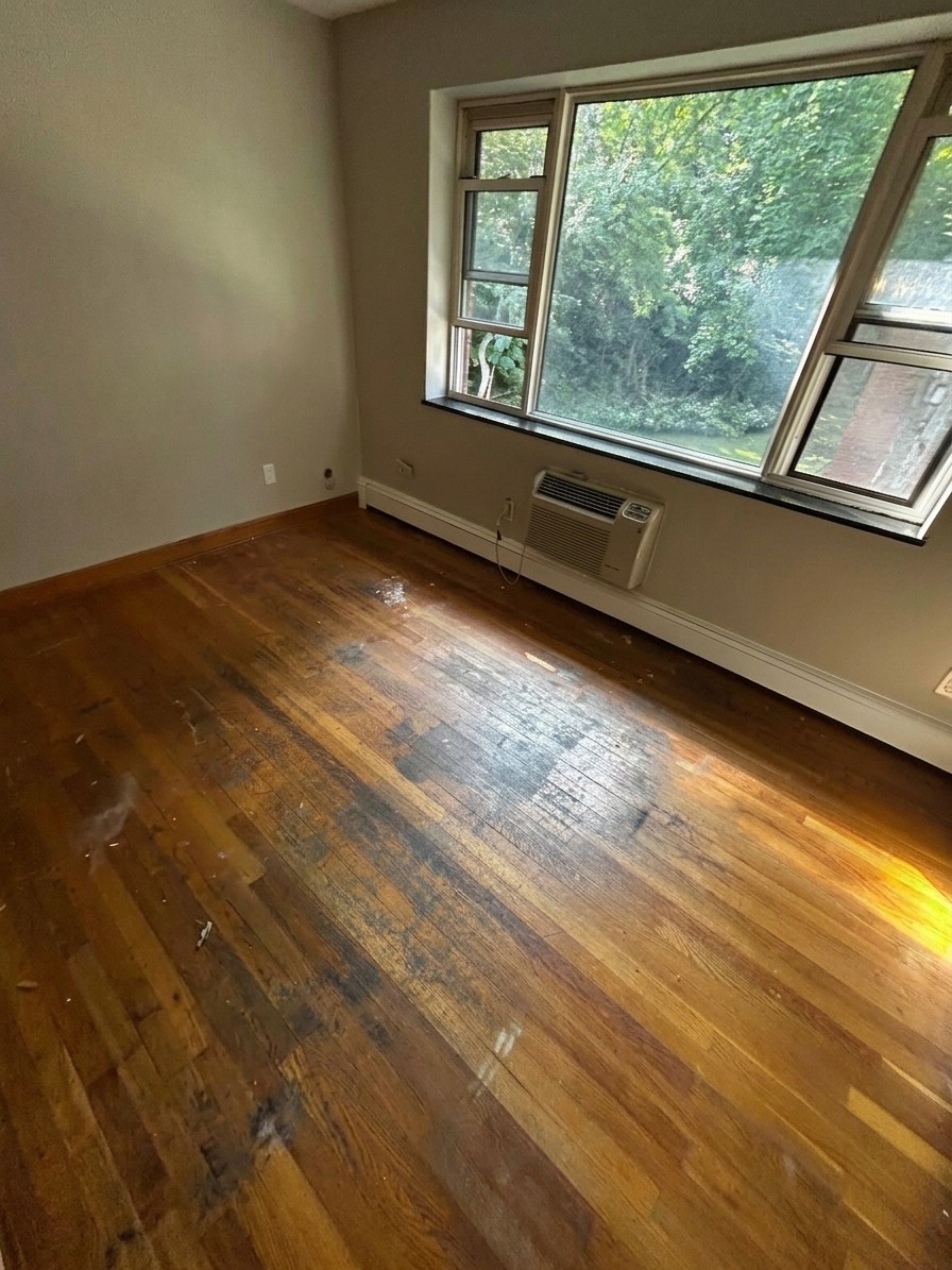 Hardwood floor before refinishing: worn, scuffed, and stained